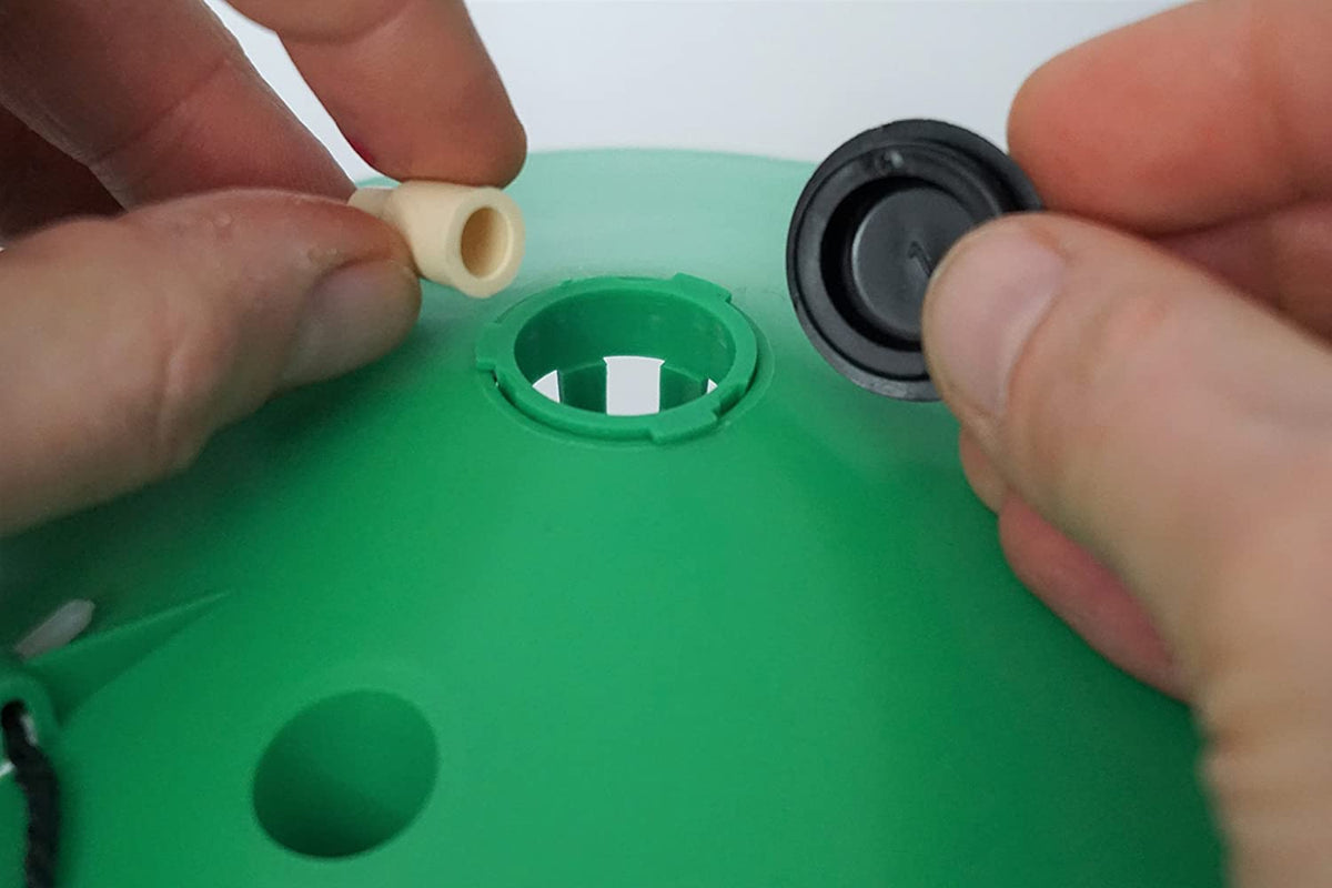 Photo of a lure being inserted into the top of the pheromone trap.